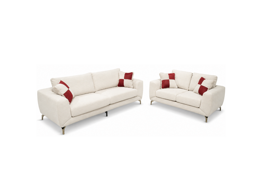 An off-white upholstered sofa and matching loveseat with red accent pillows, shown on a plain white background.