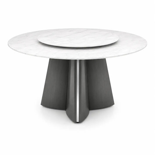 A modern round dining table featuring a white marble top with a matching inset round plate, supported by a sculptural dark gray pedestal base with a vertical metallic accent.