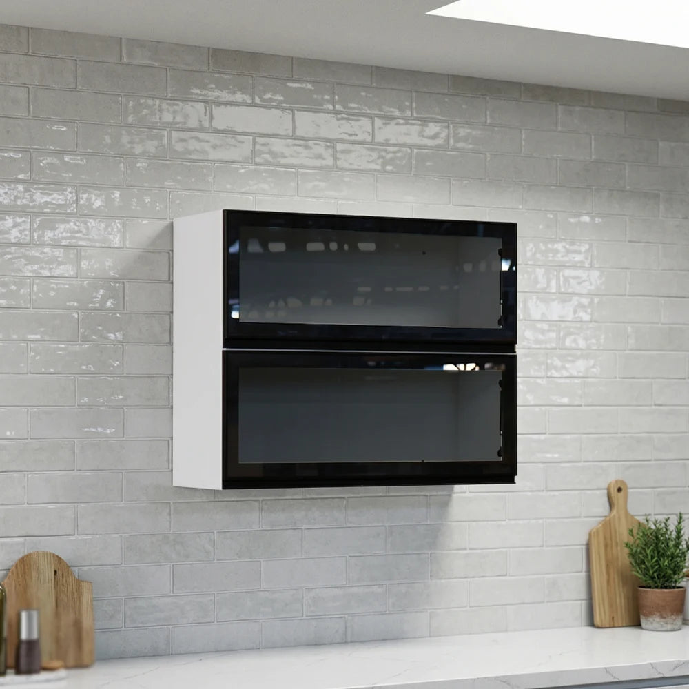 A double-door wall-mounted kitchen cabinet with a white frame and glossy black glass doors, installed on a light gray subway tile backsplash above a white countertop with small kitchen props.
