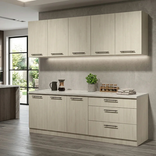 A modern kitchen cabinet set with light beige wood-grain doors and silver handles, installed against a textured gray wall with a white countertop and styled with small kitchen accessories
