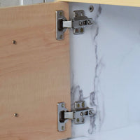 Close-up of a cabinet hinge on a wooden and marble-patterned surface