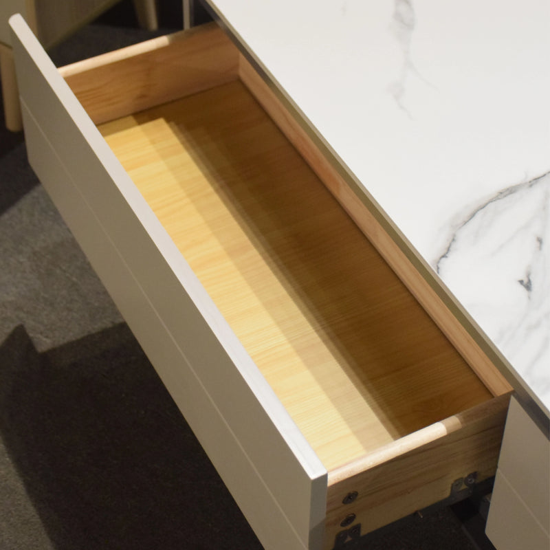 Wooden drawer with a white interior on a bed.