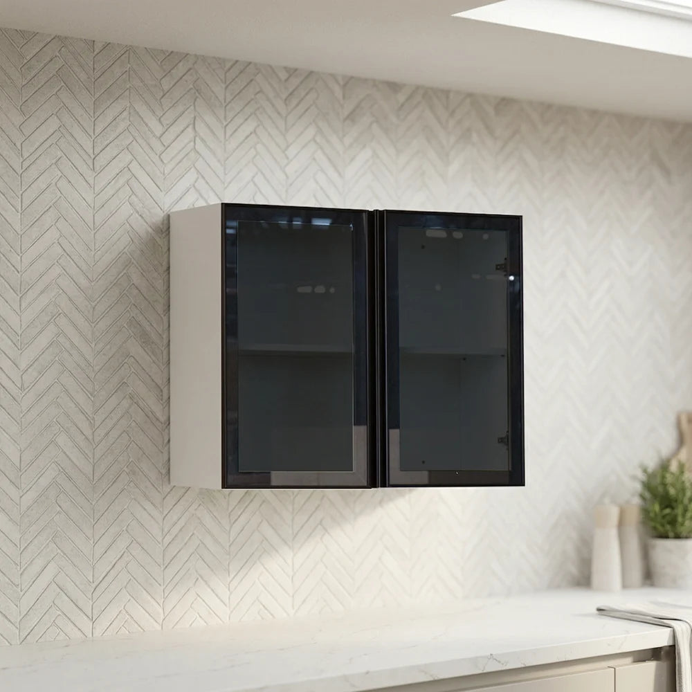 A pair of modern wall-mounted cabinets with black glass doors and white frames, installed on a white herringbone-patterned tiled kitchen wall above a white countertop.