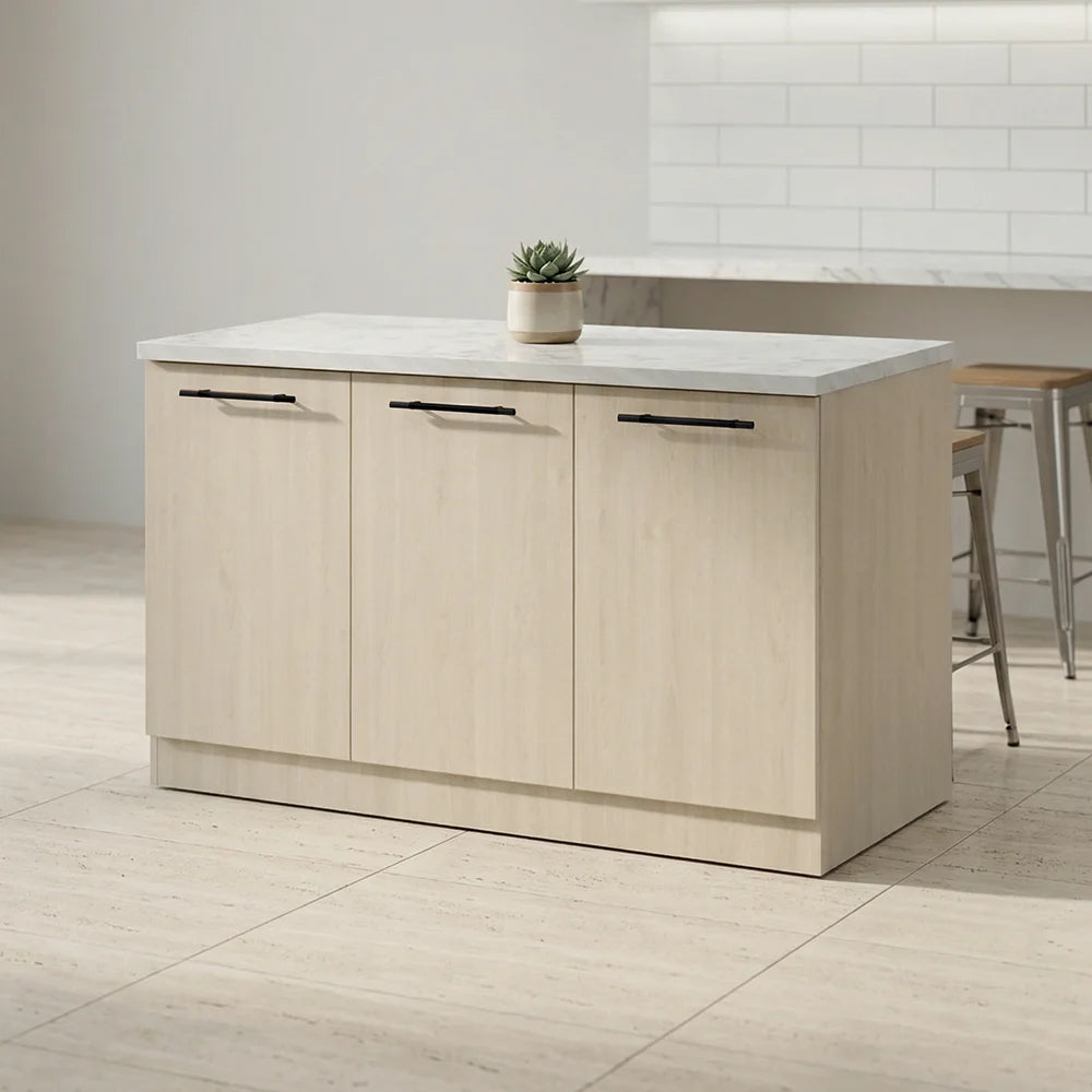 A modern kitchen island with three light wood cabinet doors, black horizontal bar handles, and a white marble-look countertop. A small potted succulent sits on top, and the island is shown in a bright kitchen setting with tiled walls and bar stools.