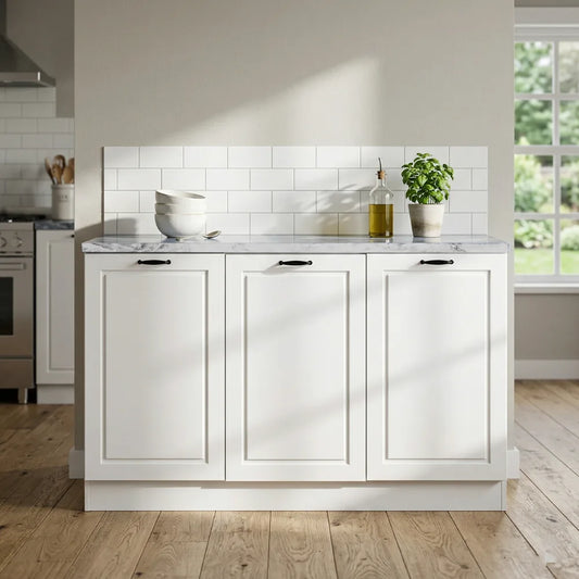 A white shaker-style kitchen cabinet island with three front doors, a white subway tile backsplash, a light marble countertop, and dark metal handles, shown in a bright kitchen setting with wood floors and a window.