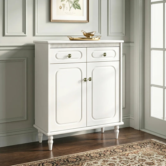 White cabinet with gold handles in a room with a painting on the wall.