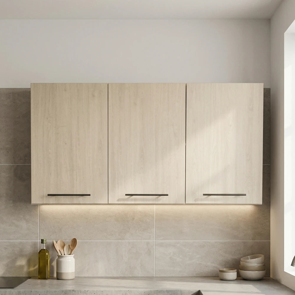 Three light wood kitchen wall cabinets with slim black handles, installed above a tiled backsplash on a kitchen countertop.