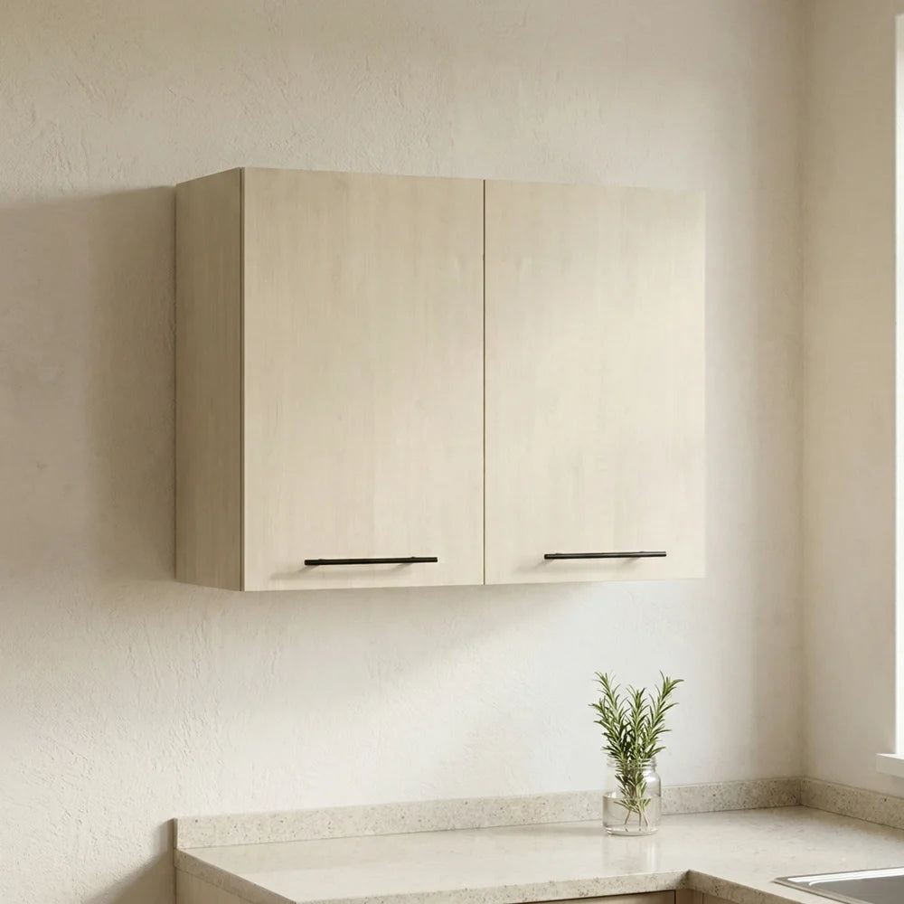 Two light beige wood-look wall cabinets mounted on a textured cream wall above a light stone countertop, with slim black horizontal handles and a small green plant in a glass vase on the counter.