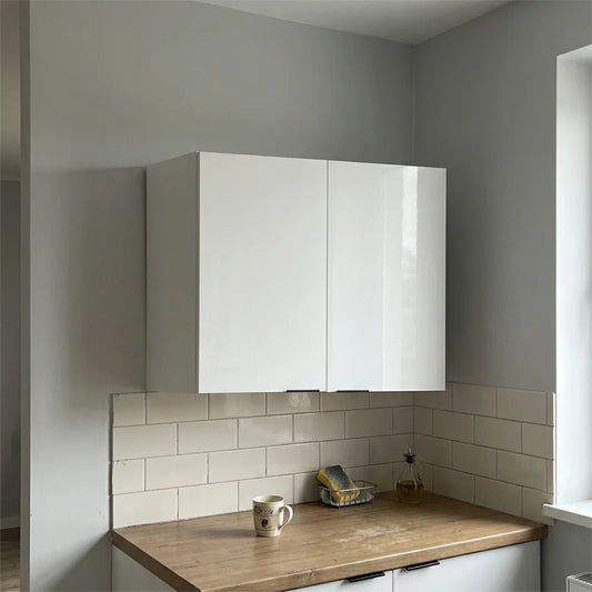 A pair of glossy white wall-mounted kitchen cabinets installed above a wooden countertop with a white subway tile backsplash